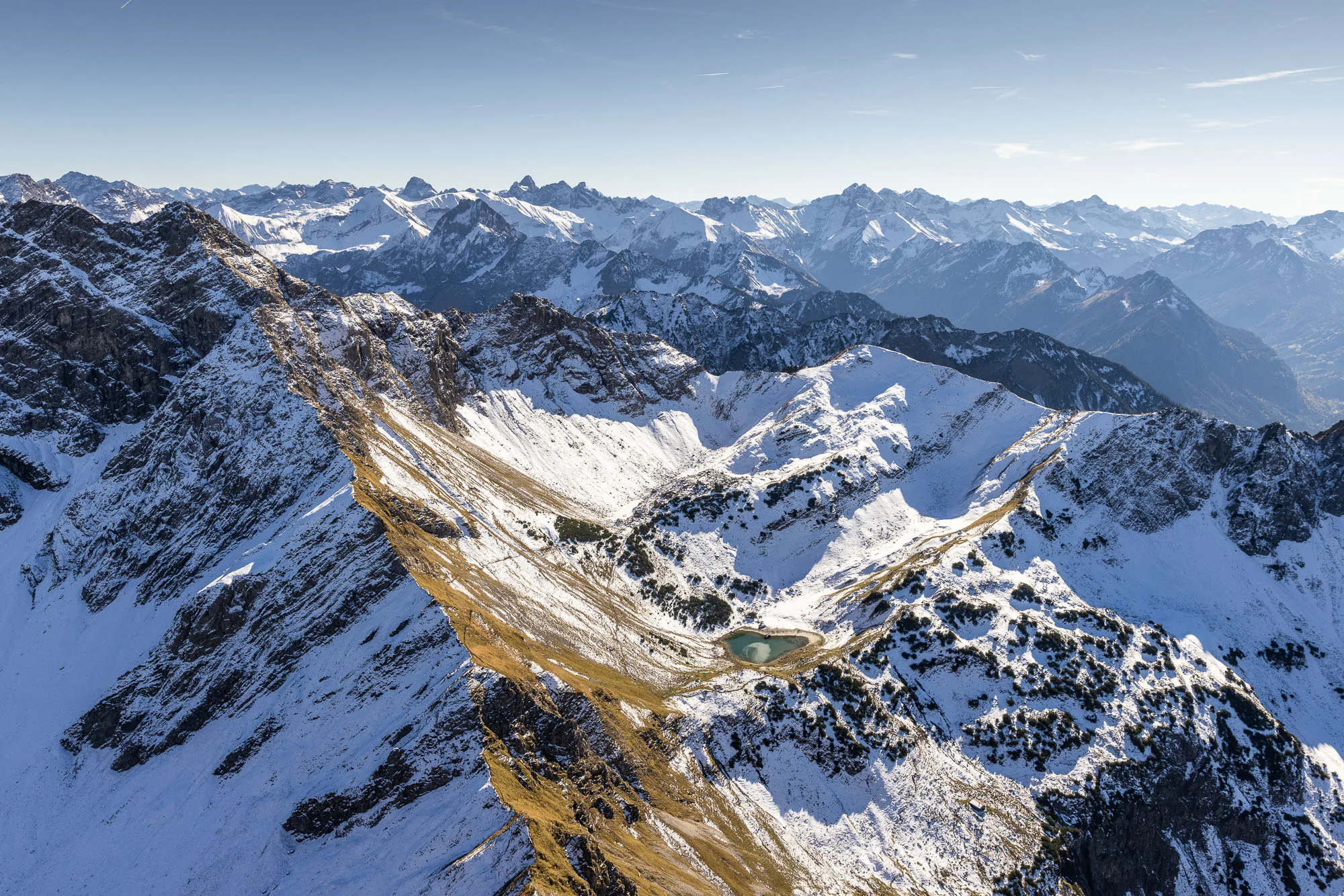 Michael Schnetzer blickt beim Flug auf den Geisalpsee und die ersten Schneefelder bei Oberstdorf.