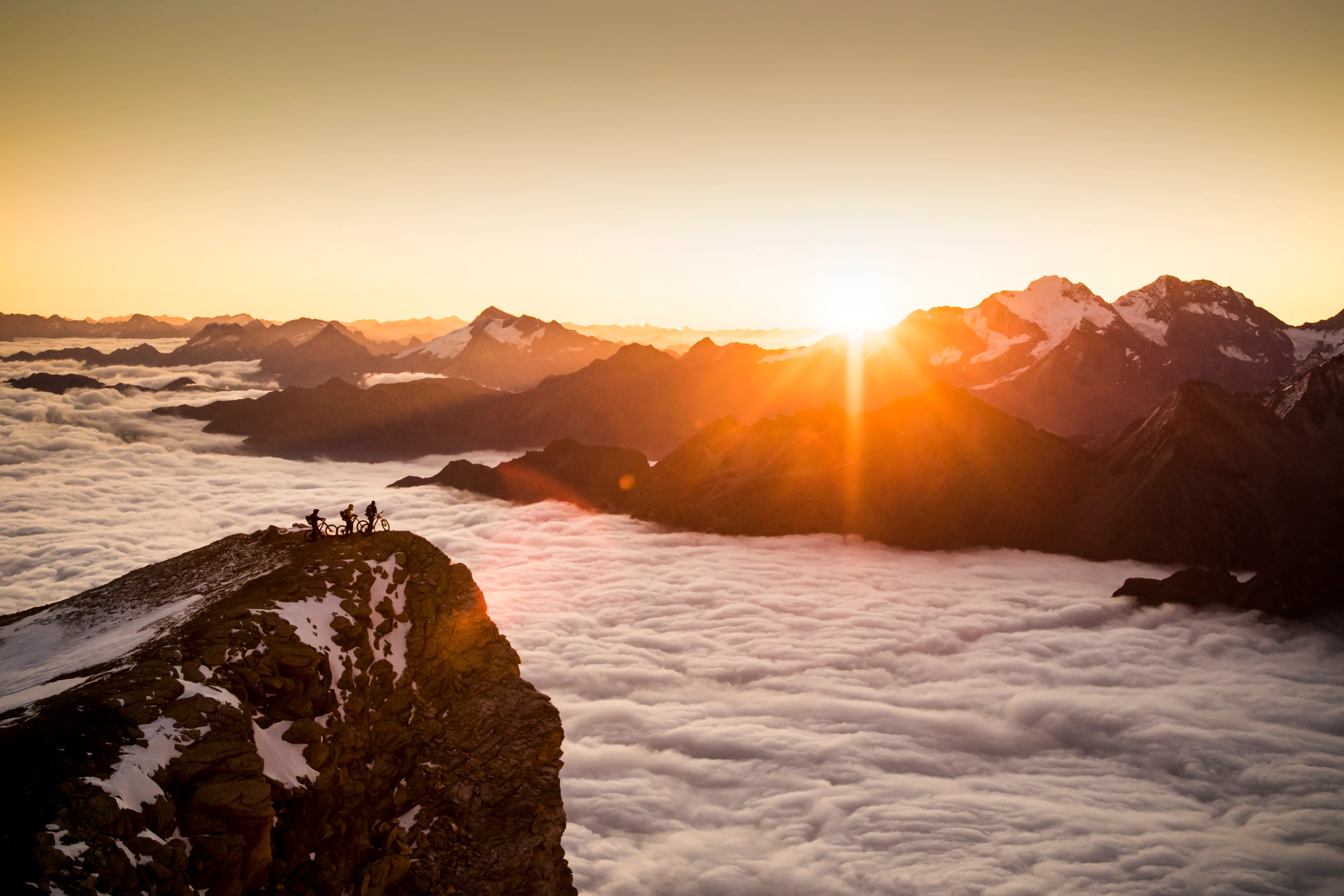 Morgenlicht legt sich über einen hochalpinen Grat und das Wolkenmeer am Barrhorn.