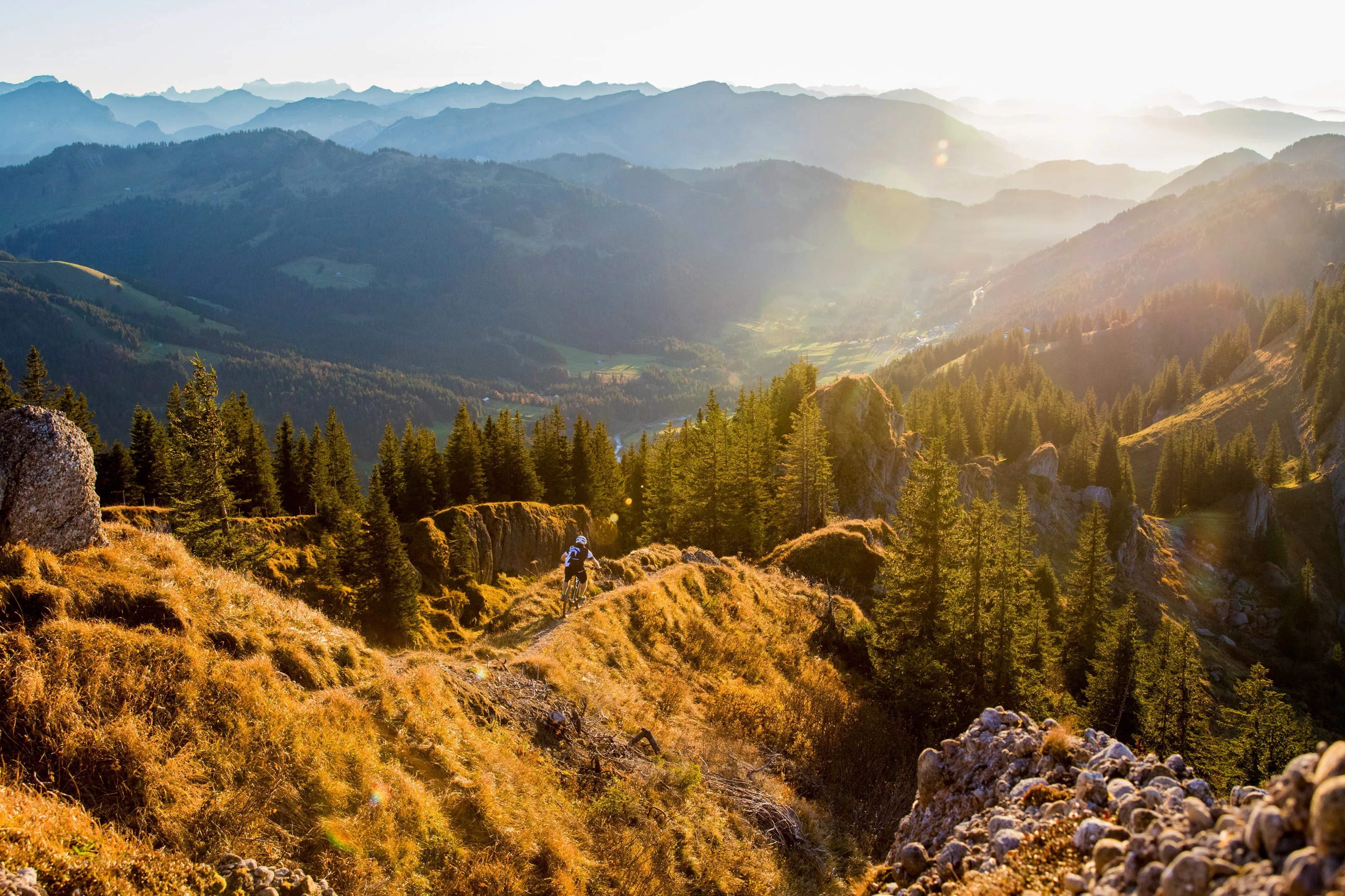 Florian Häusler fährt mit dem Mountainbike über einem Bergtal.