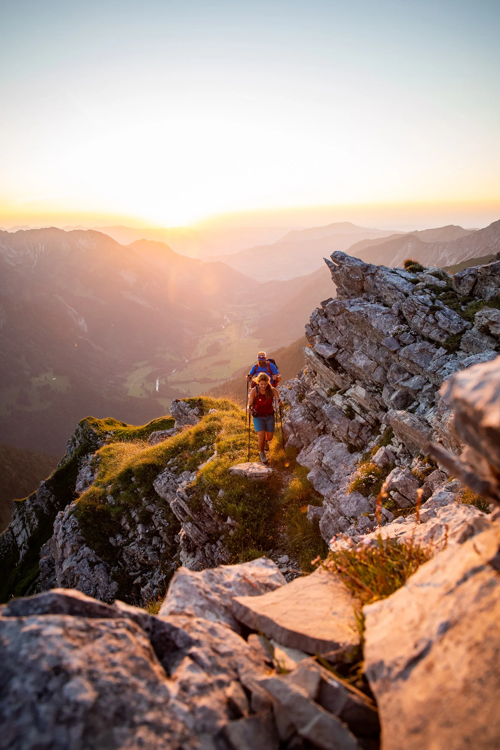 über Felsstufen an einem sonnigen Berggrat auf