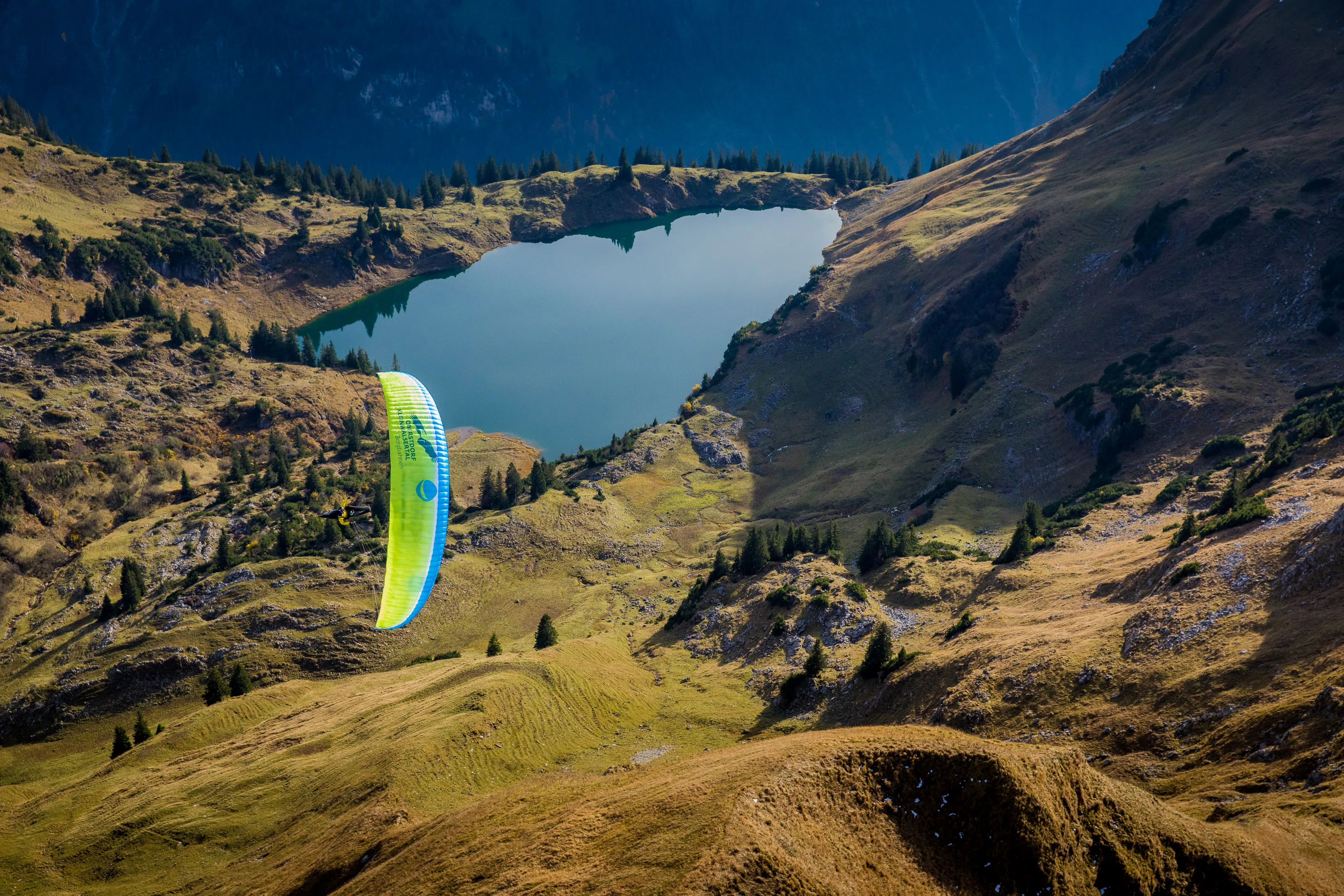 Michael Gebert gleitet am Seealpsee vorbei, unter ihm herbstliche Hänge und steinige Grate