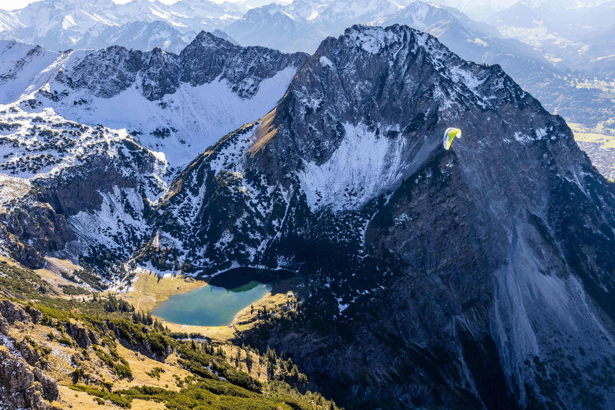 Michael Schnetzer fliegt mit dem Gleitschirm über dem Geisalpsee bei Oberstdorf.