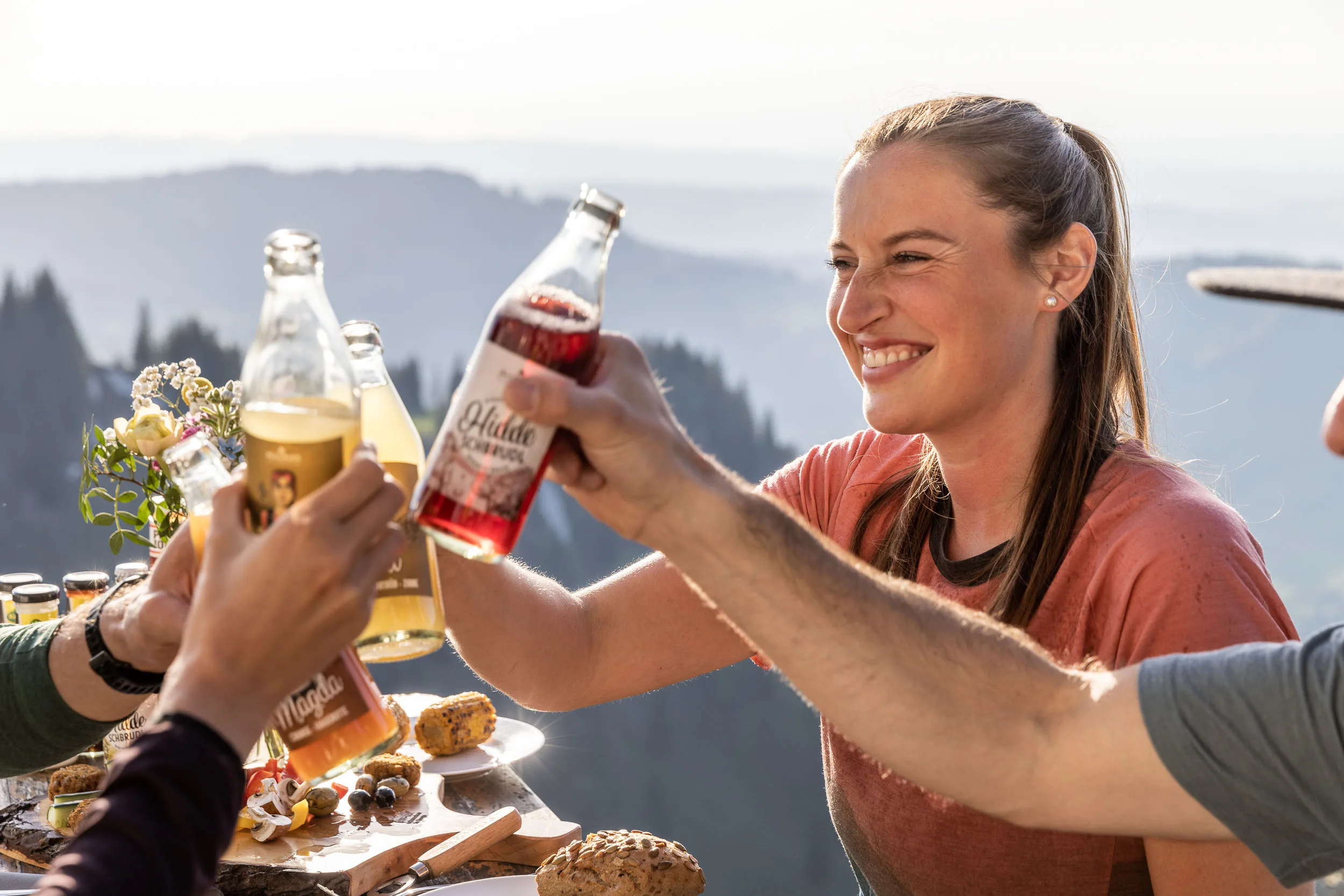 Brotzeit und Getränke auf einem Tisch mit Bergblick am Hochgrat.