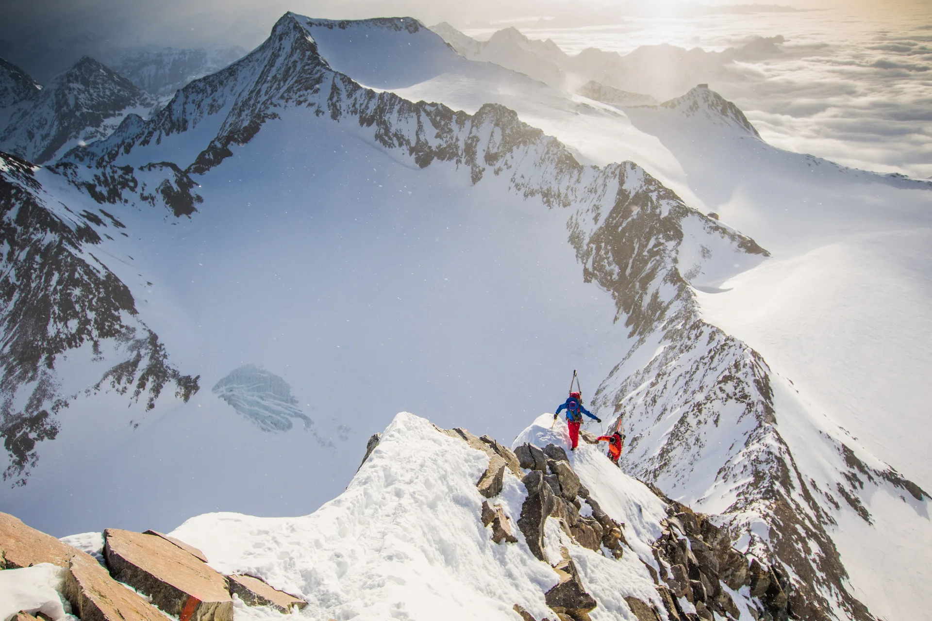 Florian Häusler und Tobias Baur stehen auf einem schmalen Schneegrat vor einem Gipfelpanorama