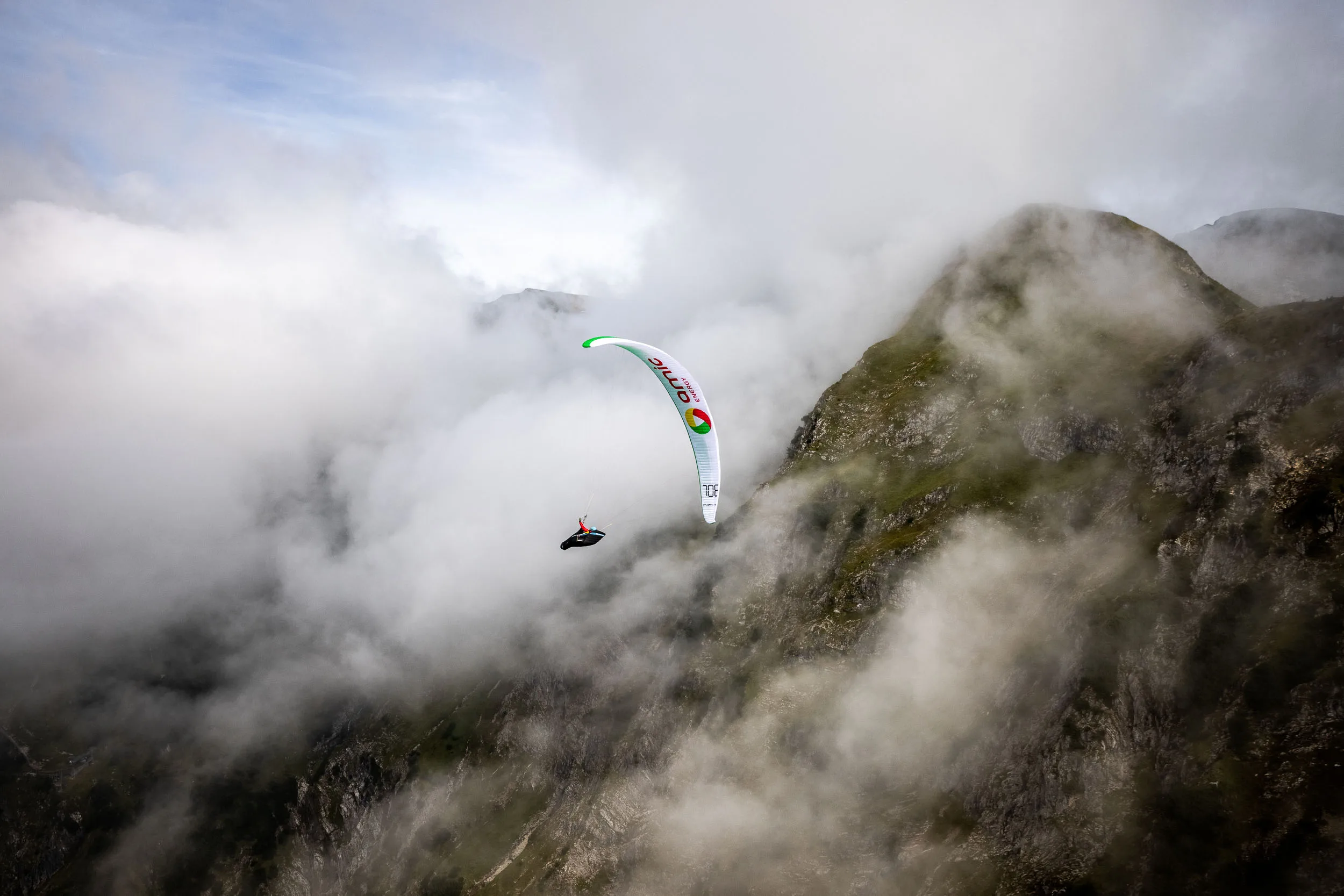 Klaudia Bulgakow fliegt mit ihrem Gleitschirm entlang einer Felswand am Nebelhorn.