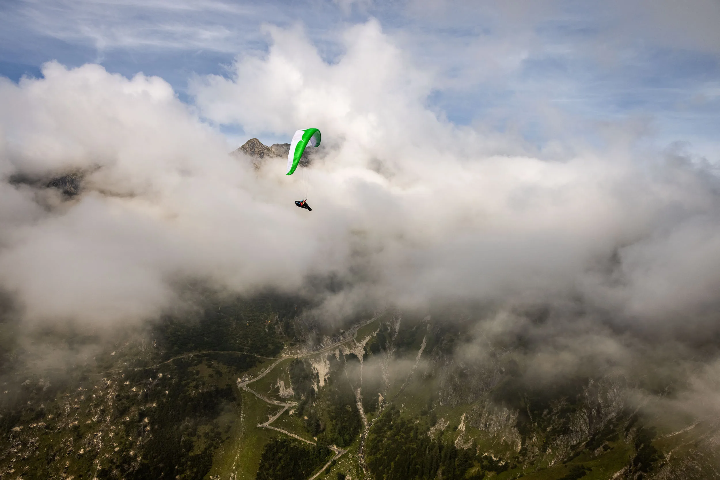 Klaudia Bulgakow fliegt mit ihrem Gleitschirm über einem Wolkenmeer am Nebelhorn.