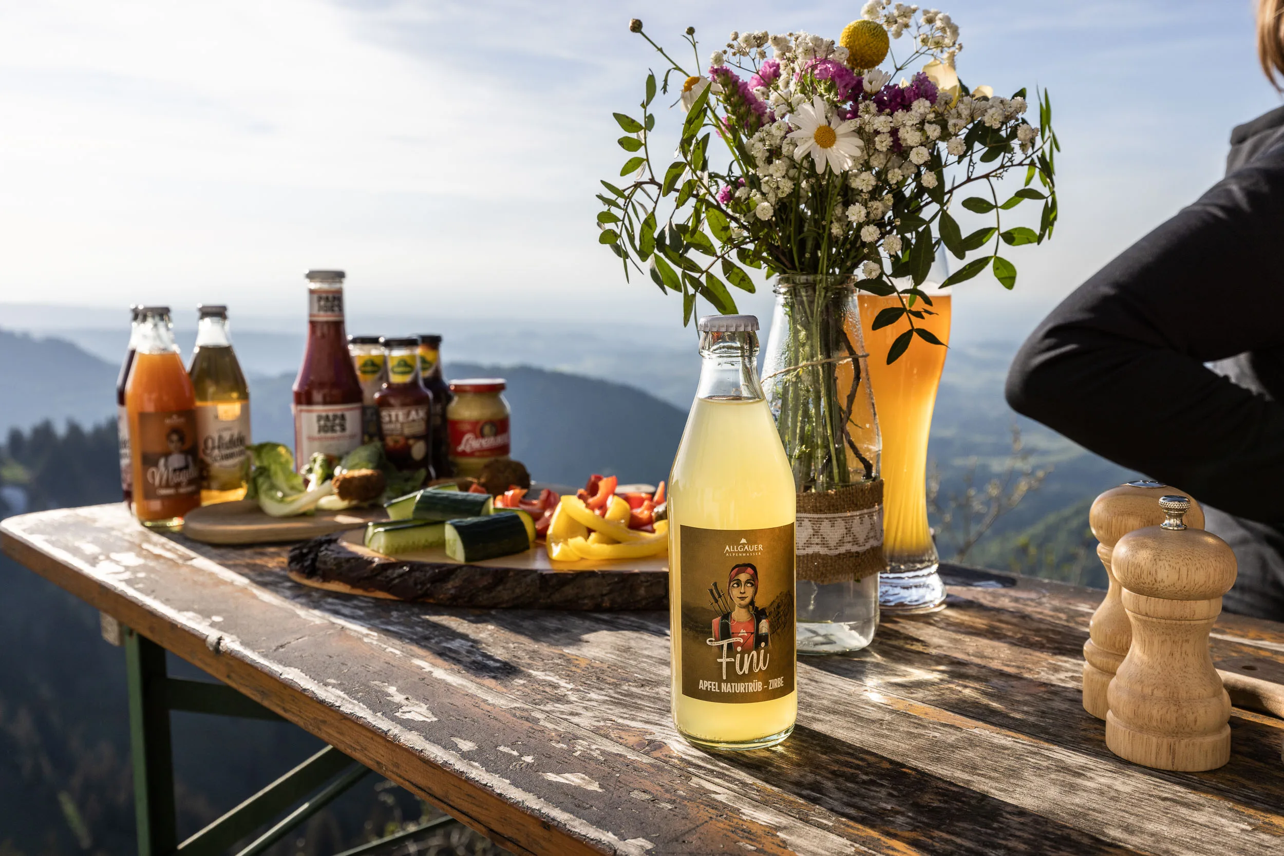 Brotzeit und Getränke auf einem Tisch mit Bergblick am Hochgrat.