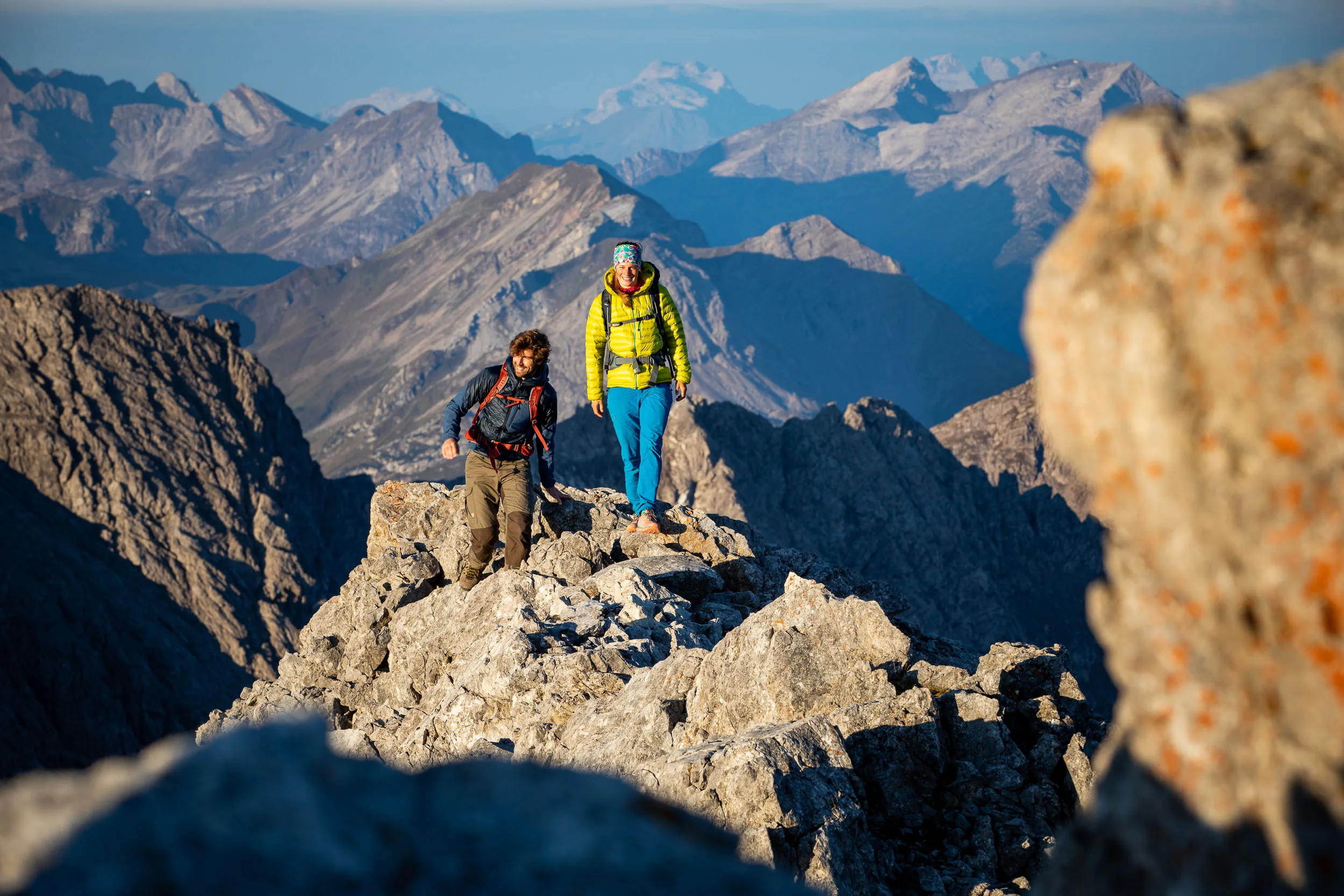 Raphaela Haug und Tom Besser wandern auf einem schmalen Felsgrat über dem Tal