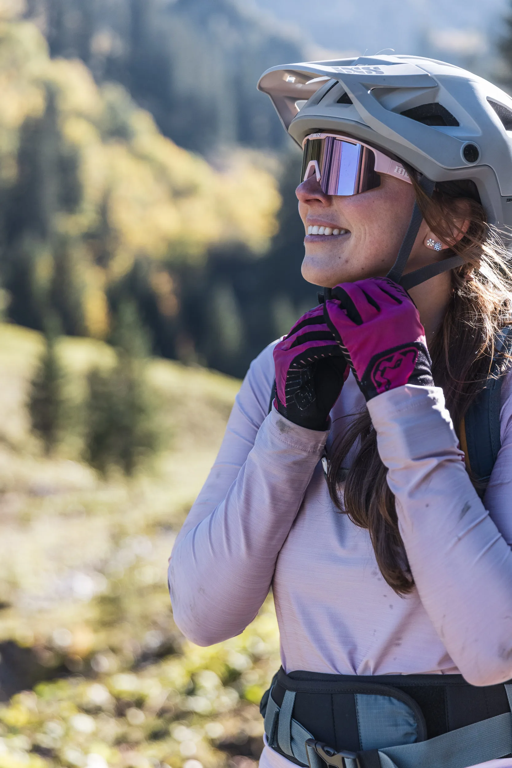 Silvi Vogel richtet ihre Brille neben dem Mountainbike im Herbstlicht