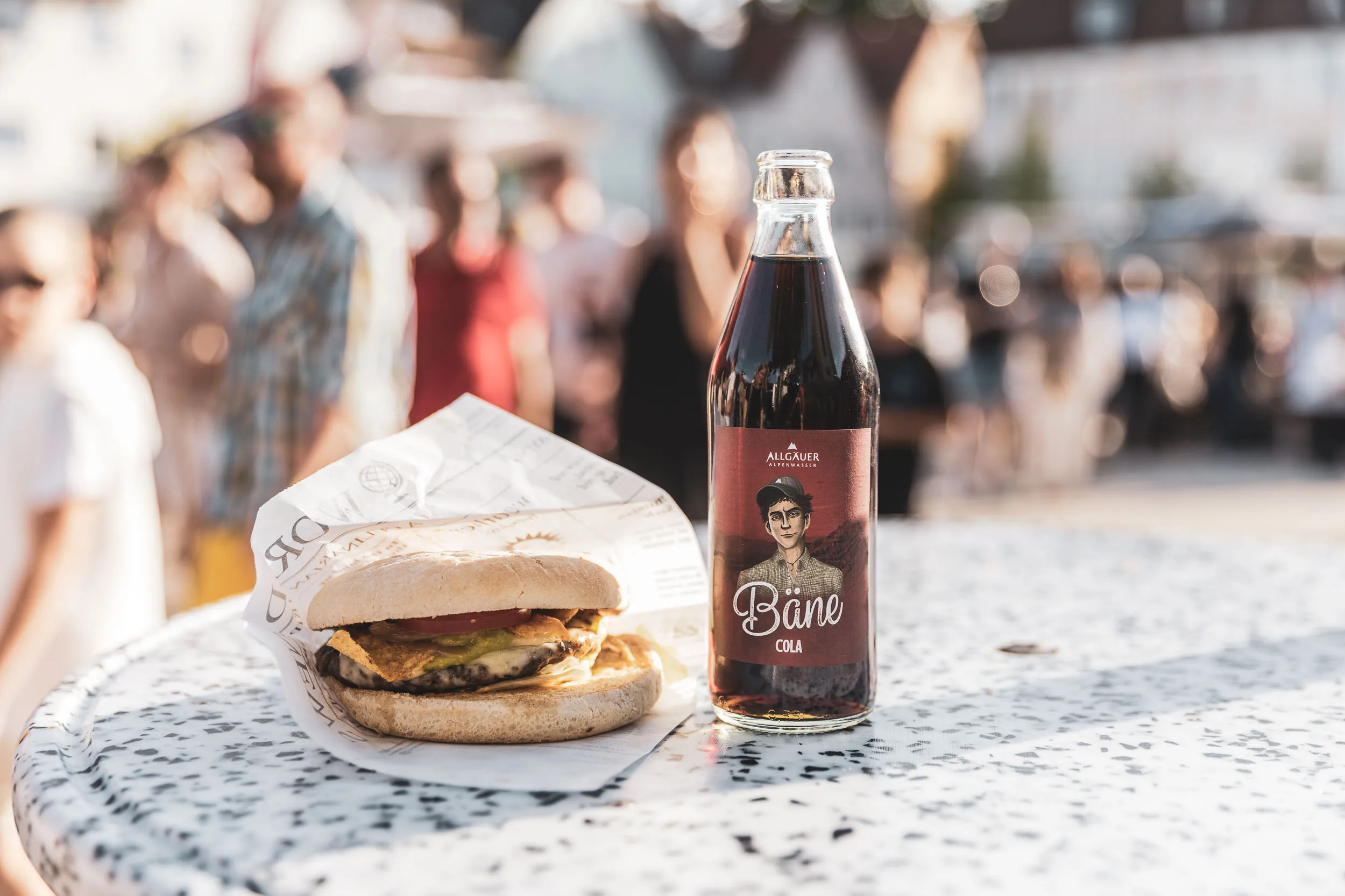 Burger und Flasche auf einem Tisch des Street Food Markts.