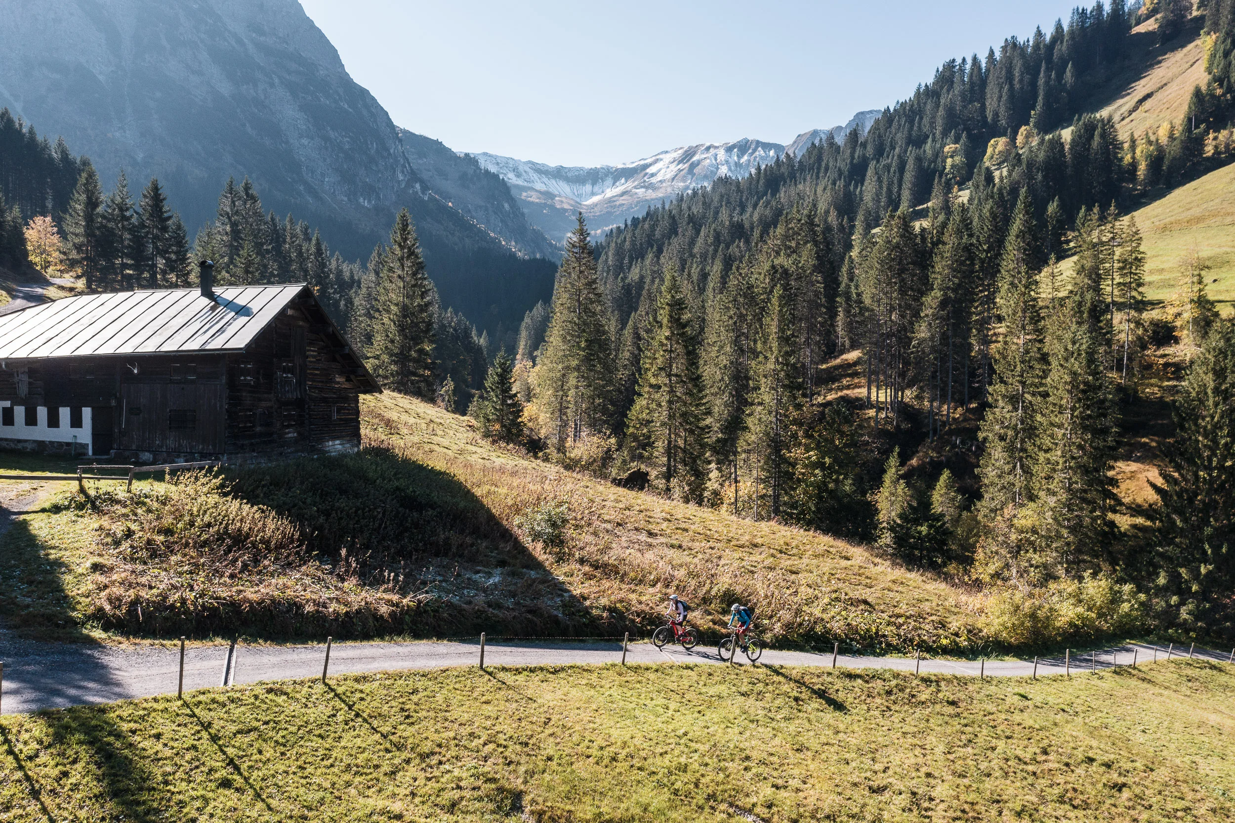 Berggasthaus und Fahrweg über dem herbstlichen Tal im Kleinwalsertal