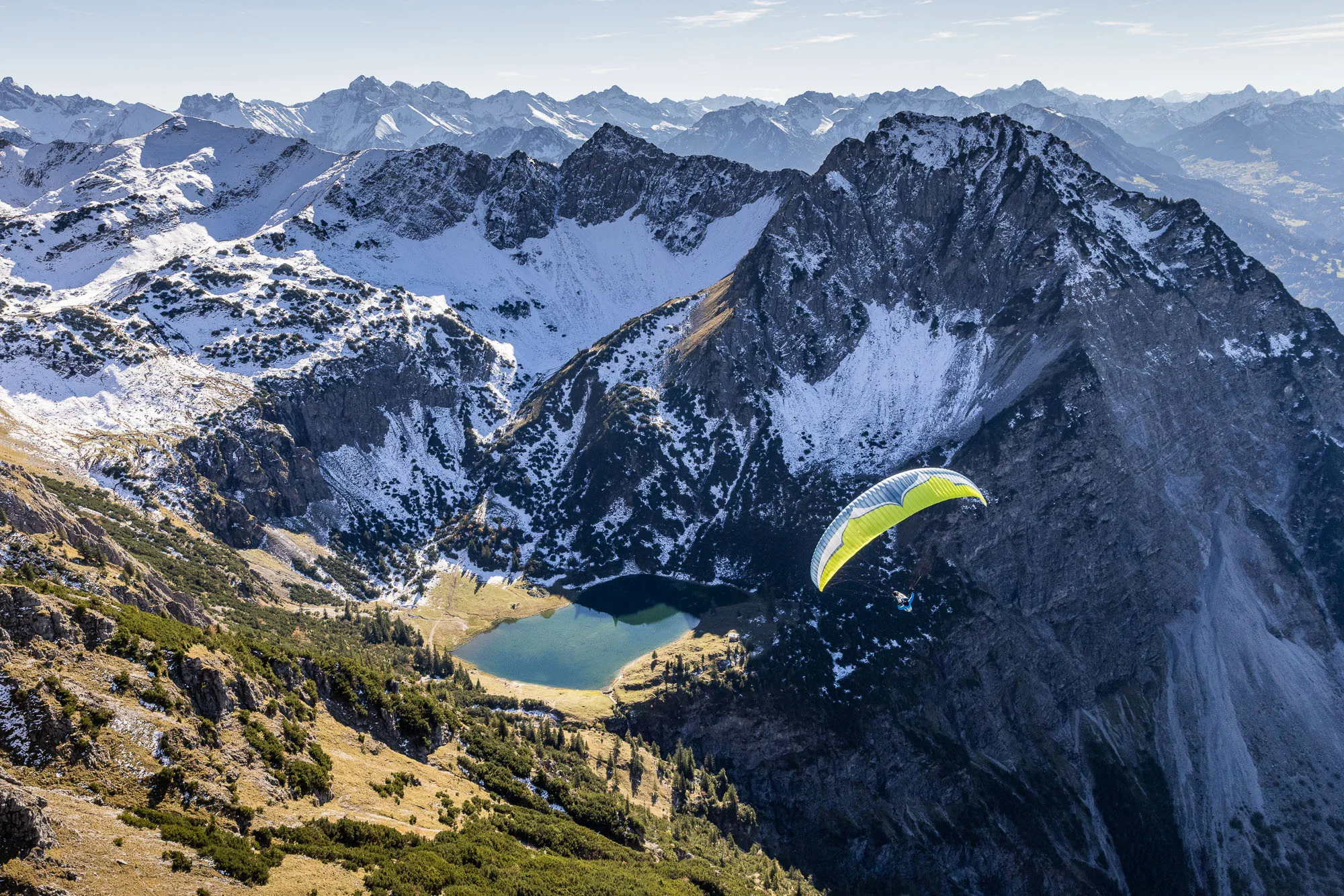 Michael Schnetzer fliegt mit dem Gleitschirm über dem Geisalpsee in den Bergen bei Oberstdorf.