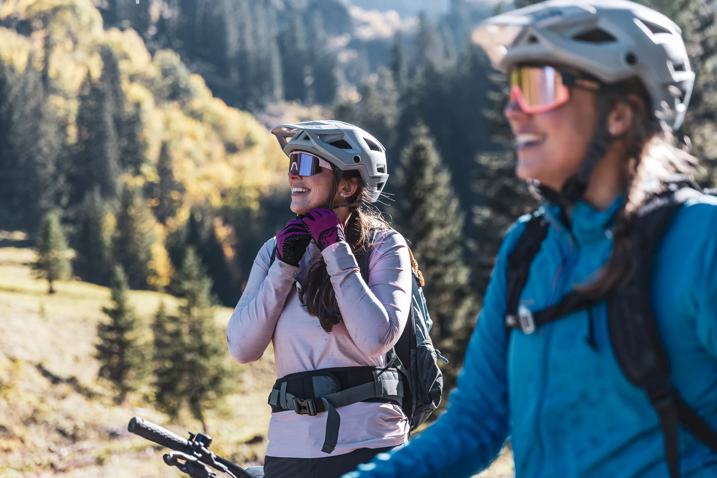 Silvi Vogel steht mit Mountainbike am Trail, Andrea Geiger ist im Vordergrund zu sehen