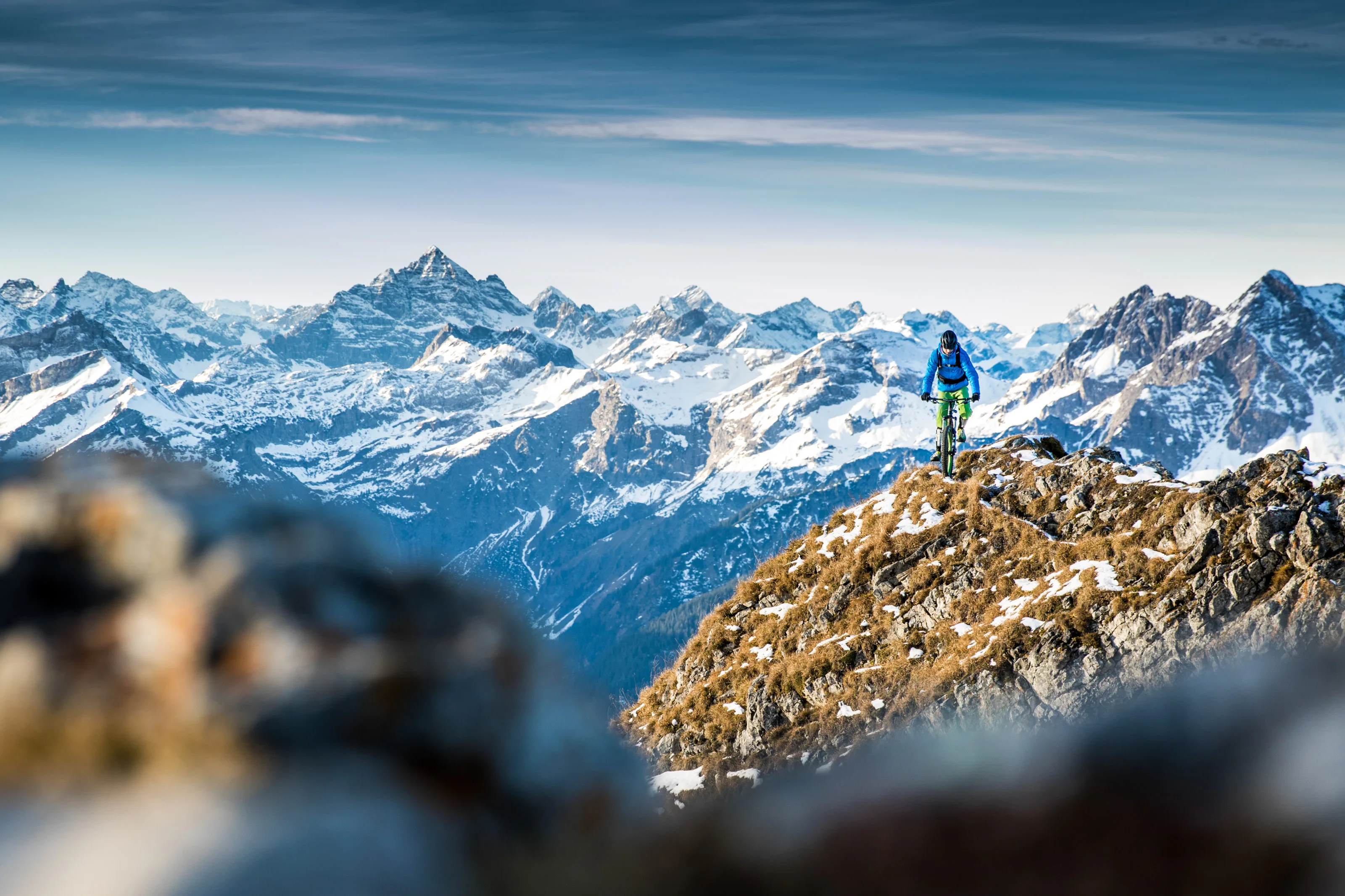 Robert Härle beim Mountainbiken vor winterlicher Bergkulisse.
