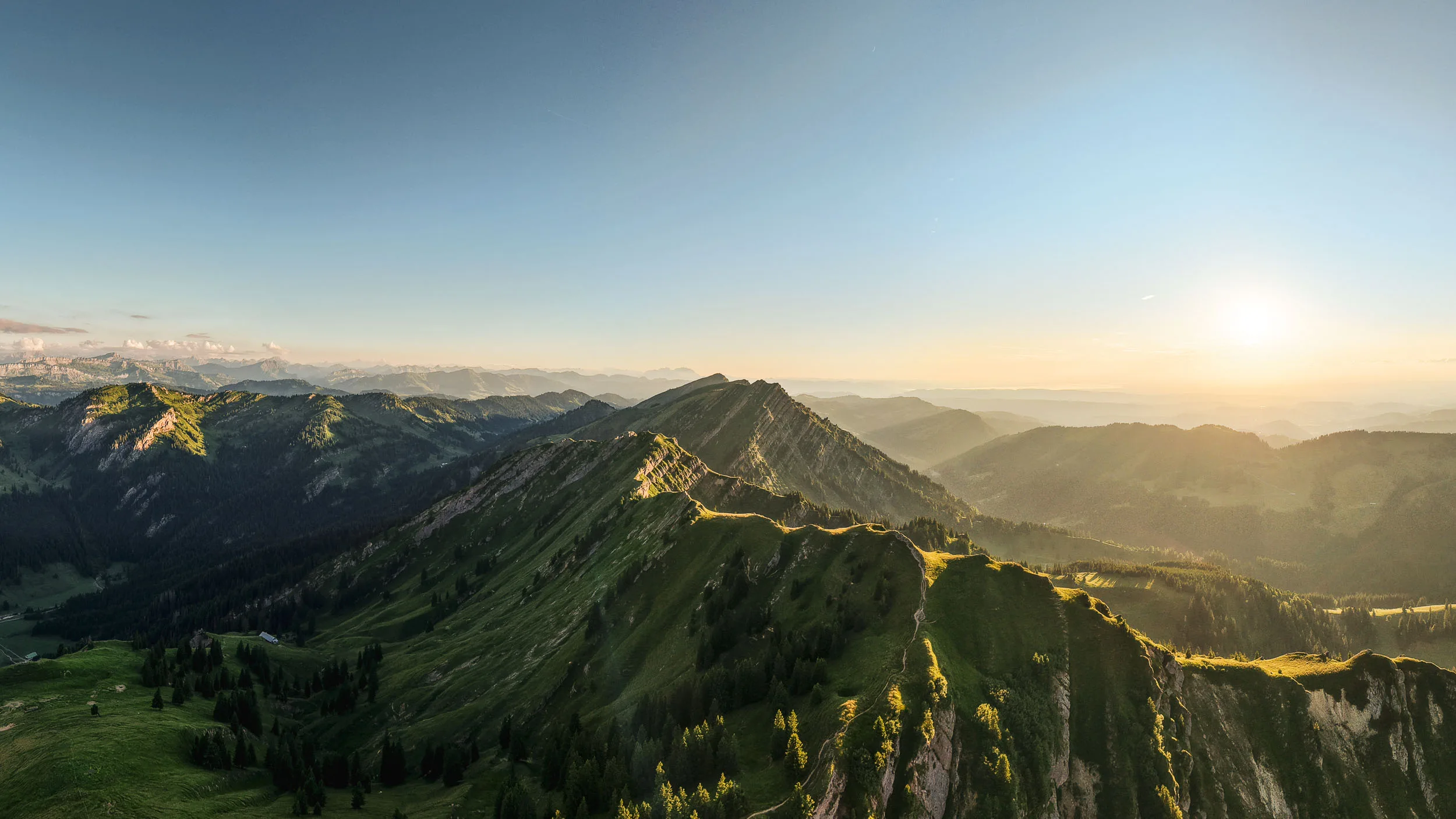 Die tief stehende Sonne beleuchtet eine lange Gratlinie und die bewaldeten Täler der Nagelfluhkette.
