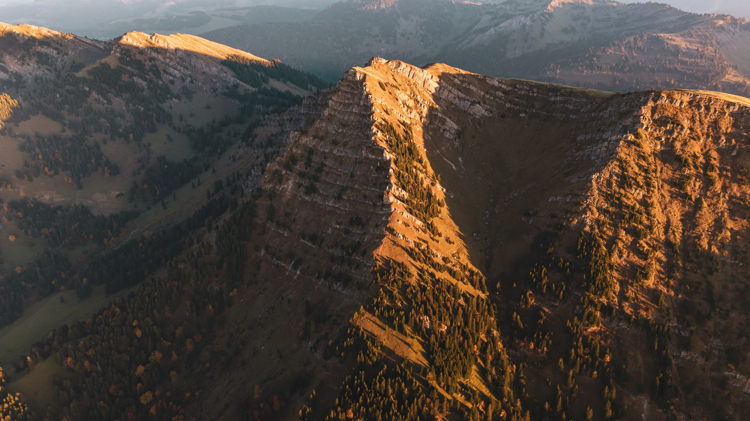 Ein steiler Bergkessel mit markanten Felswänden leuchtet in der tiefen Abendsonne