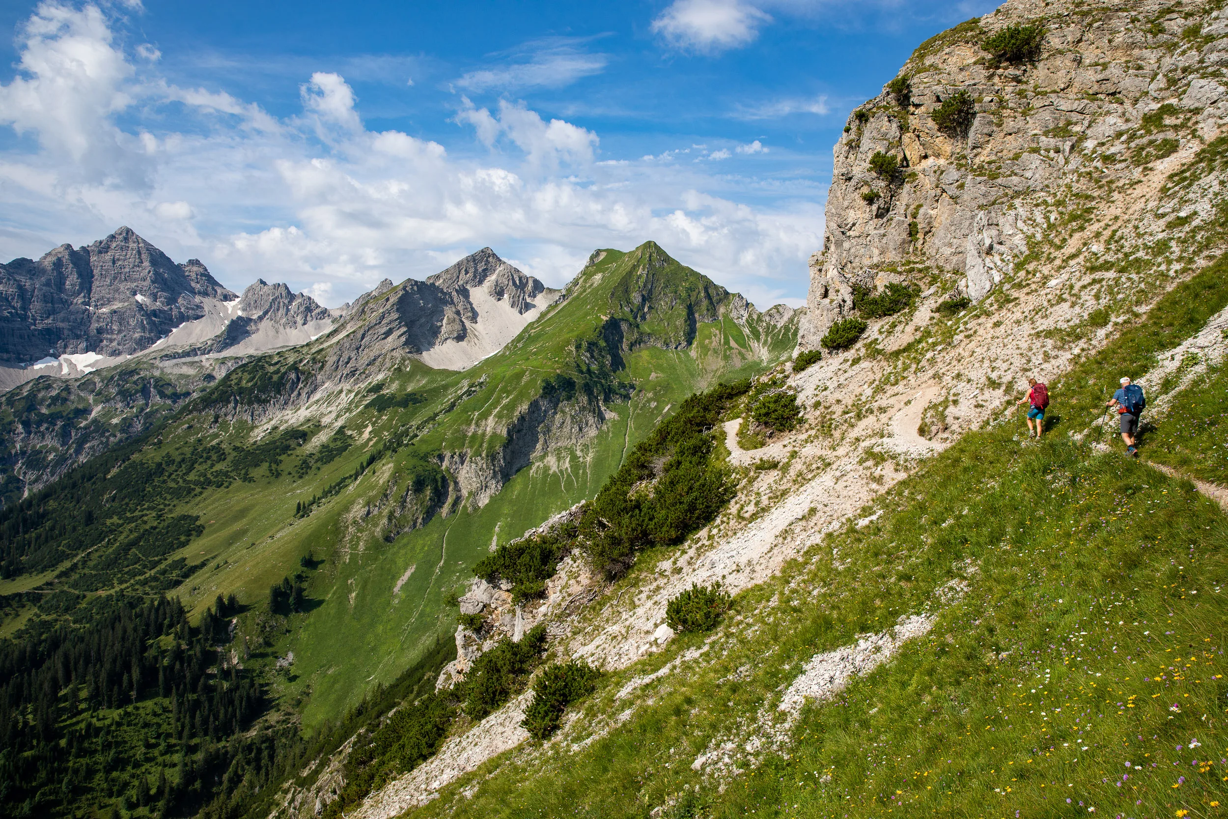 Caroline Nantke und Harald Dreyer wandern auf einem schmalen Hangpfad unter einer Felswand