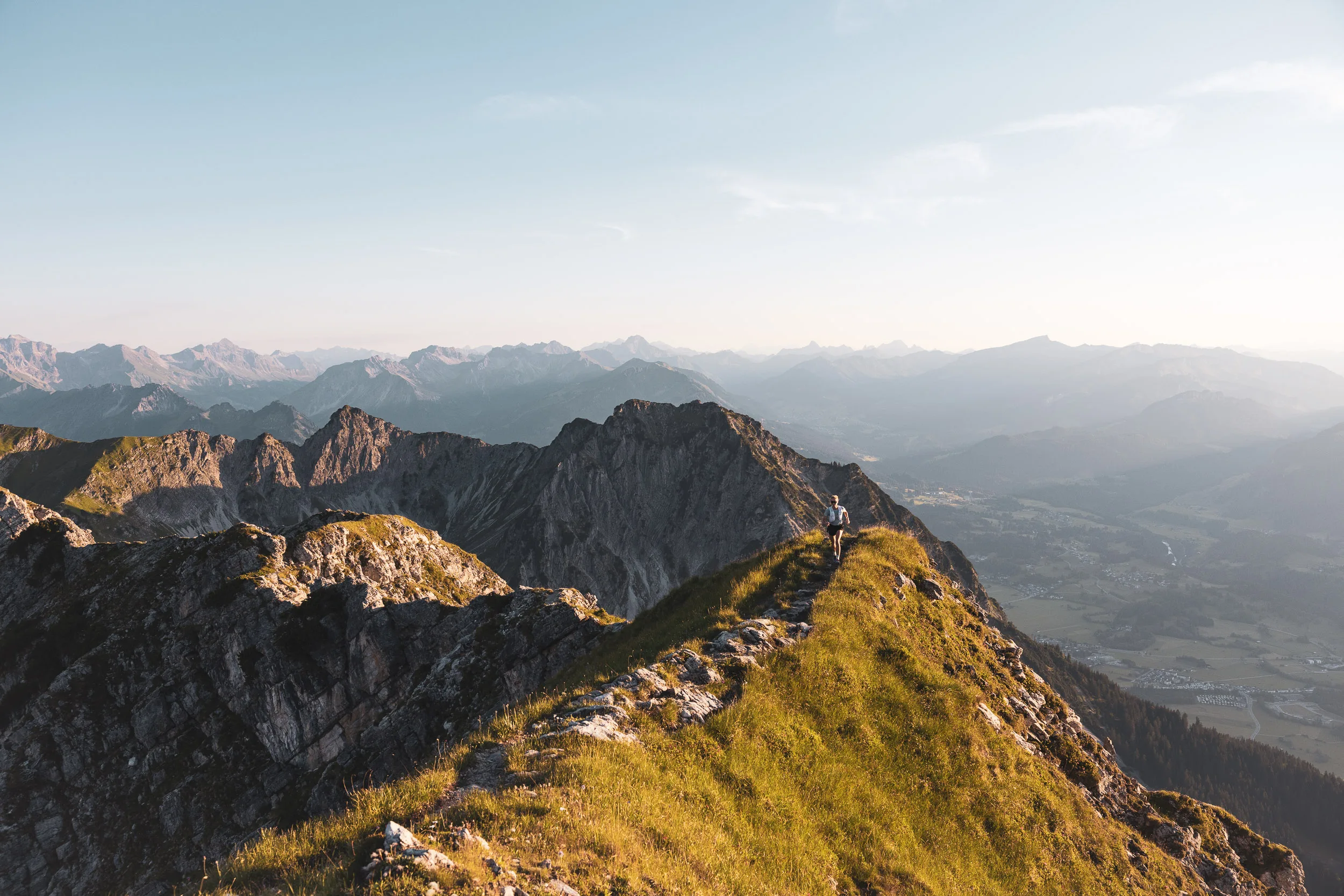 Berggrat im weichen Abendlicht vor gestaffelten Alpengipfeln