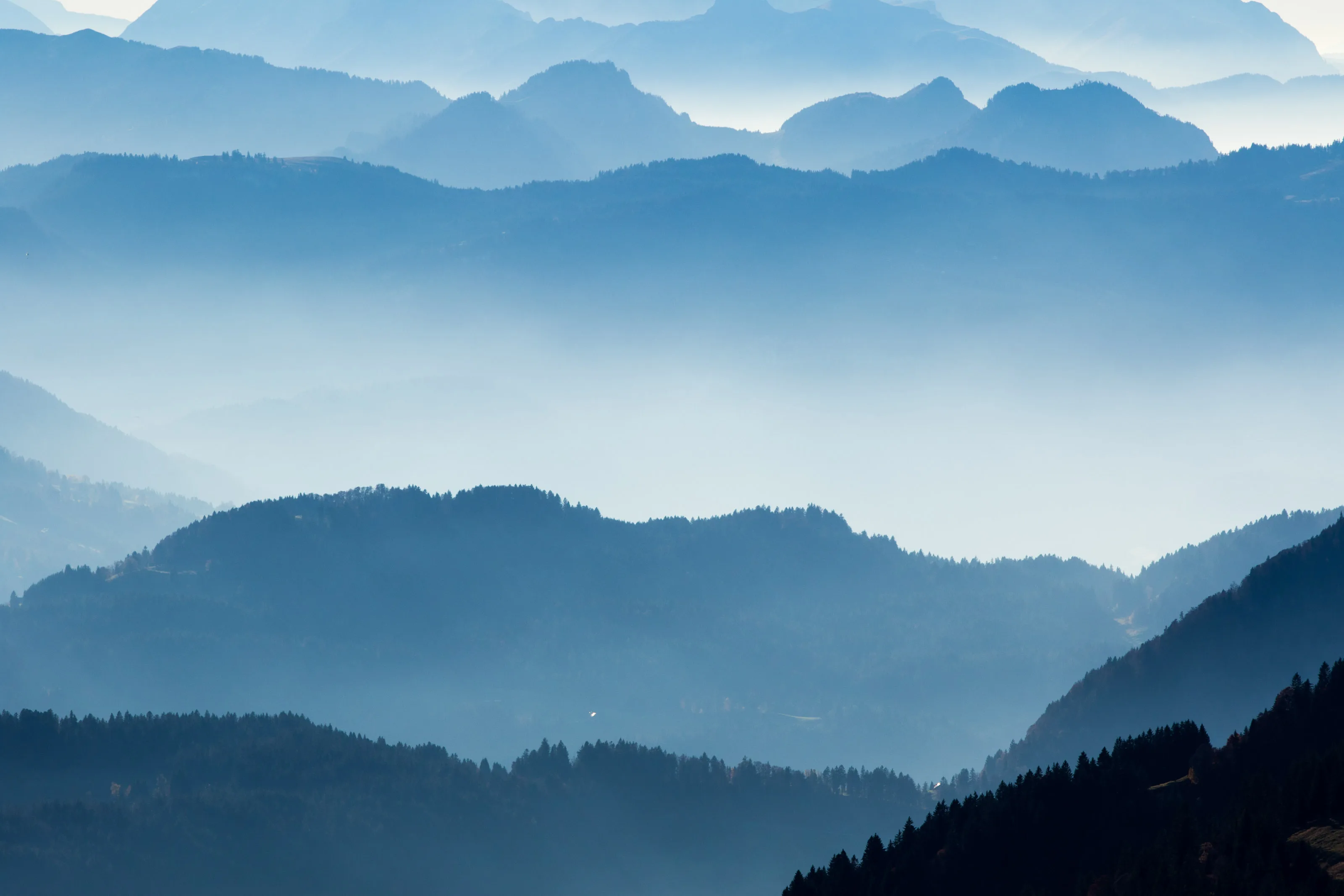 Hügelketten und Bergsilhouetten in dunstiger Fernsicht.