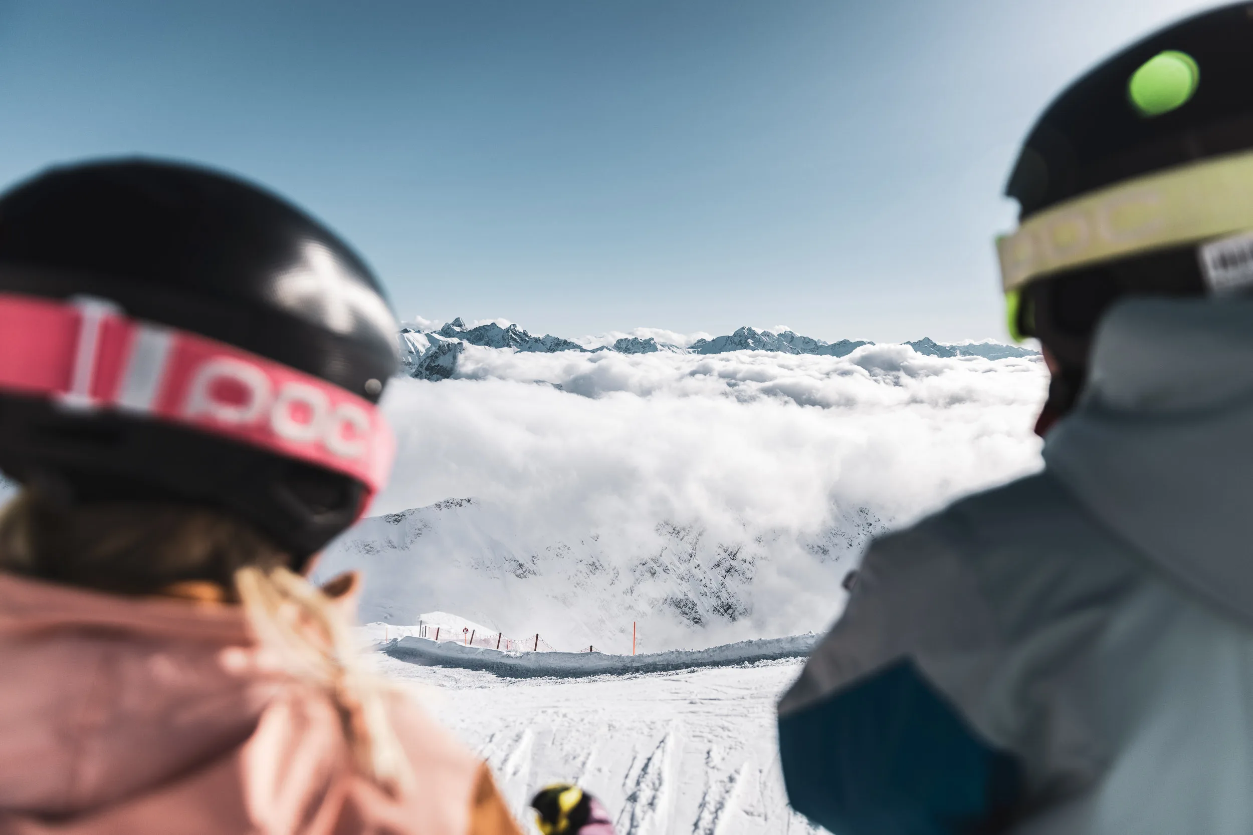 Zwei Kinder blicken vom Nebelhorn über die Wolkendecke in die Berge