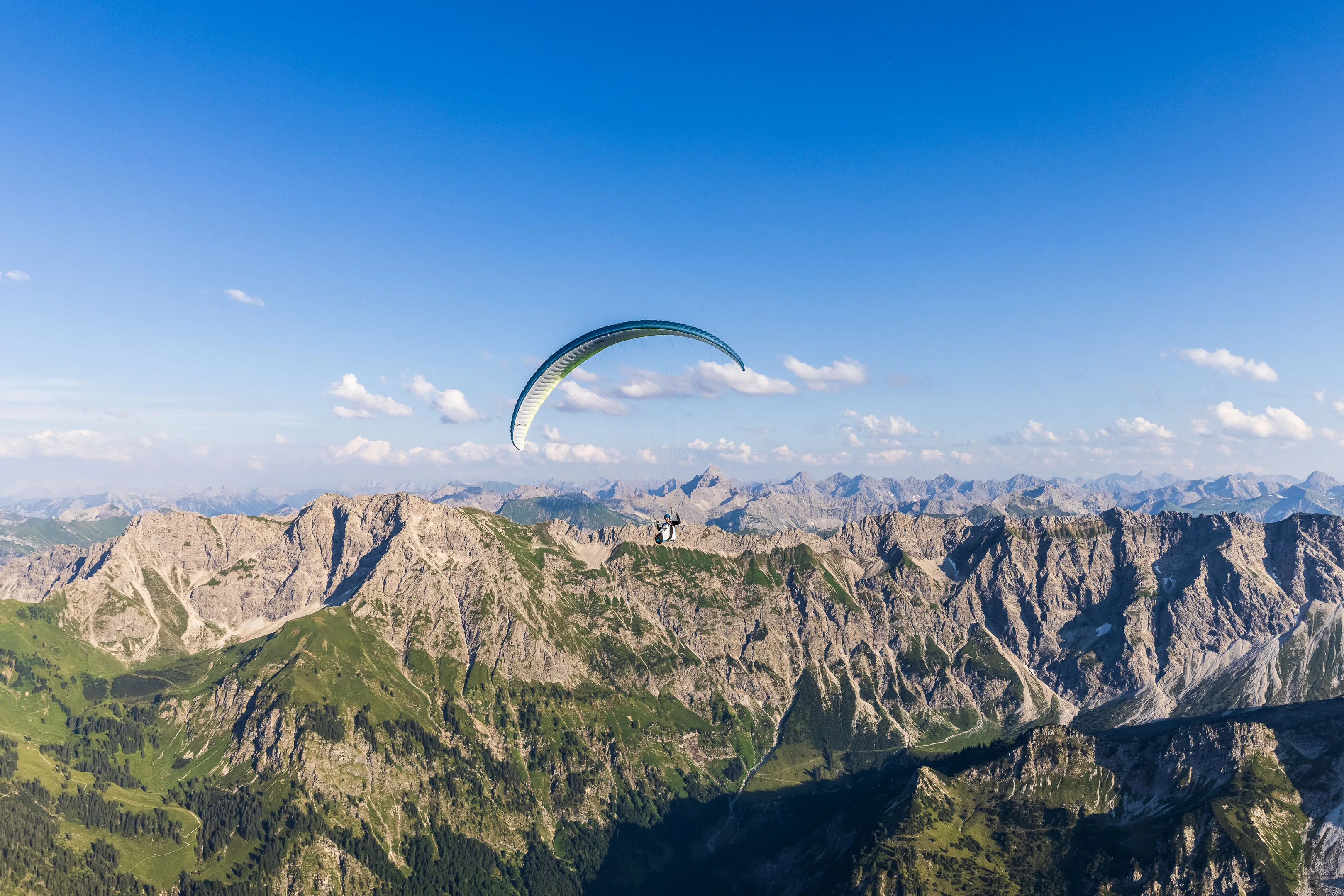 Michael Schnetzer fliegt vor einer scharf gezackten Bergkette im klaren Abendlicht