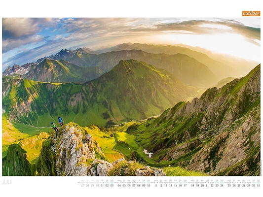 OUTDOOR Kalenderseite Juli mit Bergsteigern über einem grünen Allgäuer Hochtal im warmen Abendlicht